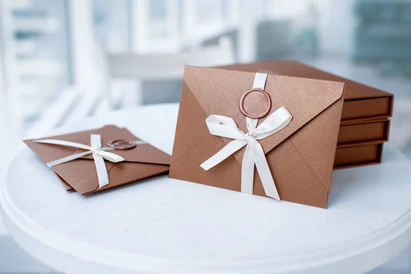 Gift Certificate, gift voucher or discount. close-up photo of bronze invitation envelope with a ribbon and wax seal, a gift certificate, a card, a wedding invitation card