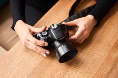 Odessa / Ukrayna - 02-04-2020: Fotoğraf stüdyosunda kamera kanonu olan genç bir kadının eli yakın çekim. fotoğrafçı günü konsepti