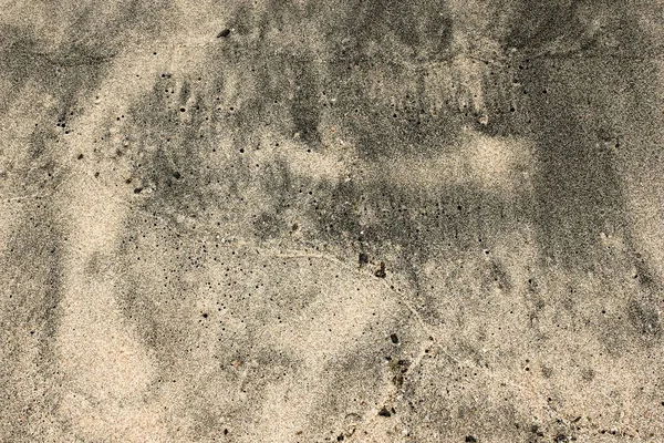 Brun och grå våt sand konsistens på stranden — Stockfoto