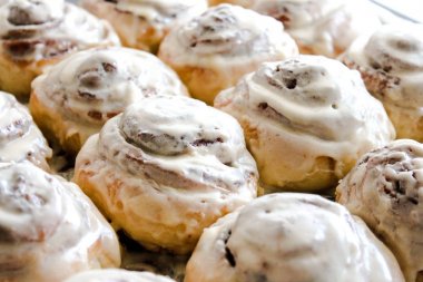 Lezzetli beyaz parlak tarçınlı çörek yığını kapat