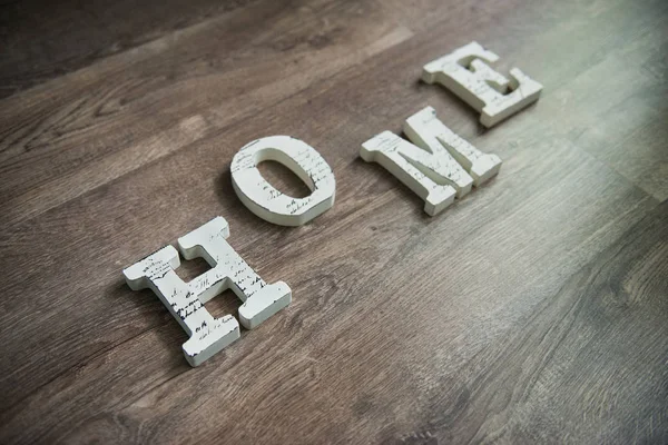 Białe drewniane litery "Home" na podłoże drewniane — Zdjęcie stockowe