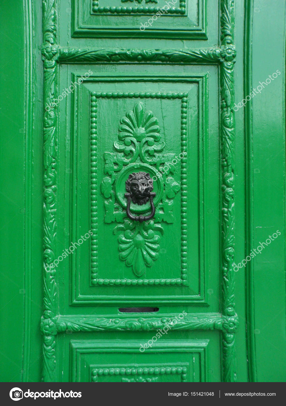 Black Lion Head Knocker On Green Door Stock Photo