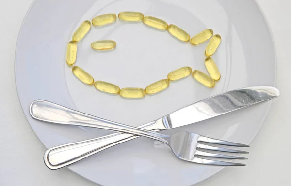 Balık şekil Cod Liver Oil tablet plaka üzerinde