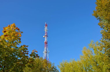Cep telefonu iletişim radyo tv Kulesi, direk, hücre mikrodalga anten ve verici mavi gökyüzü ve ağaçlar karşı