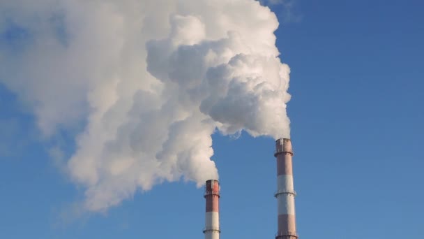 Znečištění ovzduší z továrny. Kouř a trubky na pozadí modré oblohy — Stock video