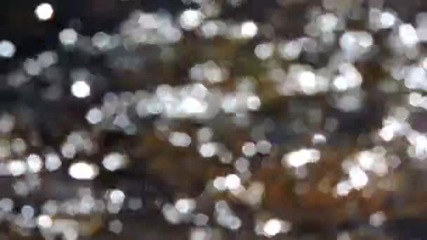 Superficie de agua espumosa, el sol se refleja y produce destellos de estrellas — Vídeos de Stock