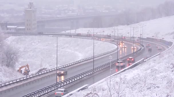 Voitures conduisant sur une route enneigée en hiver, circulation sur l'autoroute en cas de chute de neige, blizzard — Video