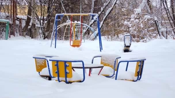 Barnens gunga svänger från vinden på vintern, barnens lekplats i snön — Stockvideo