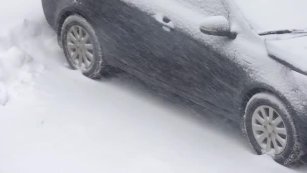 Winter. Schneefall. Verschneites Auto steht bei Schneesturm am Straßenrand — Stockvideo