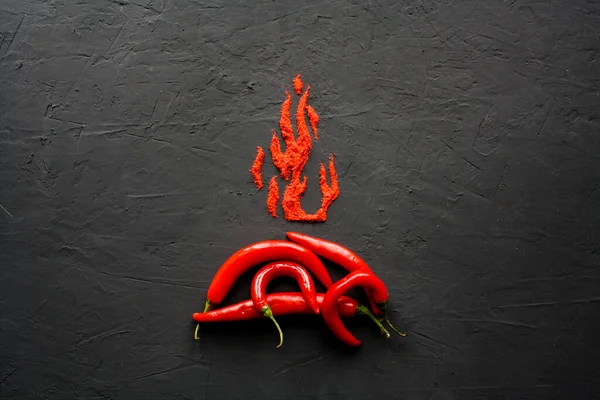 至近距離で黒い表面に炎の花弁の形で散在パプリカと赤熱カプセル ロイヤリティフリーのストック写真