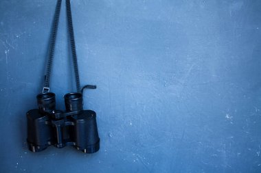 Dürbünler odak noktasında, duvarın arka planında asılı duruyor. Metin, illüstrasyon, fotoğraf posteri için boş bir boşluk var.