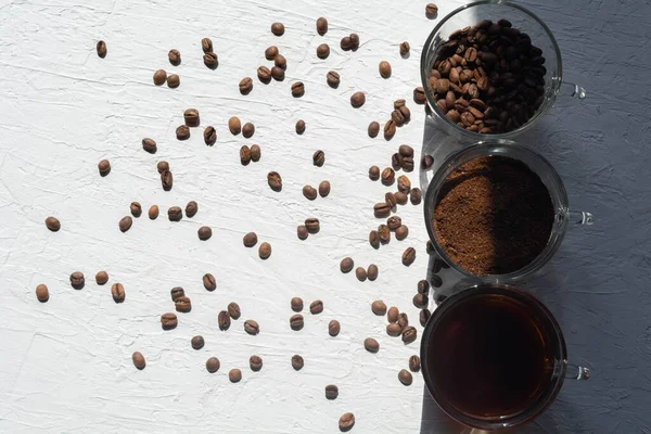 Trois tasses de café moulu, grains de café et café infusé dans une rangée — Photo