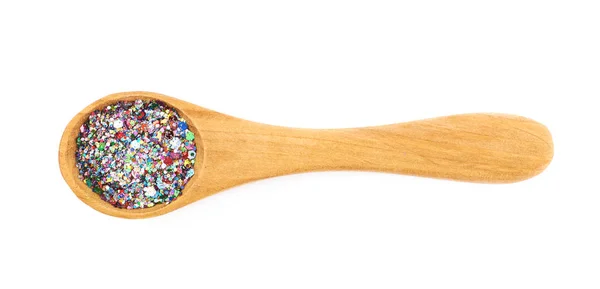 Wooden spoon full of sequins — Stock Photo, Image