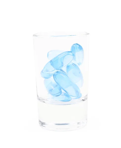 Shot glass full of softgel pills isolated — Stock Photo, Image