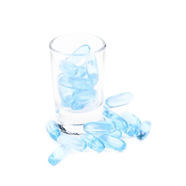 Shot glas vol softgel pillen geïsoleerd — Stockfoto