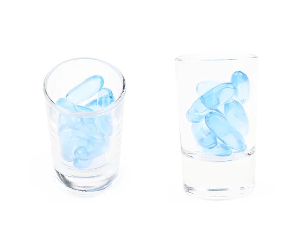 Colpo di vetro pieno di pillole softgel isolato — Foto Stock