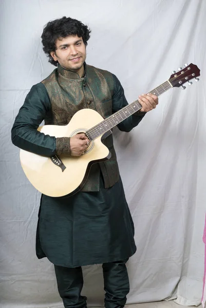 indian male model in green kurta holding guitar