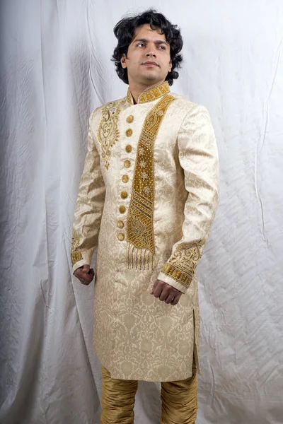 Indian groom in golden sherwani posing for picture. | Photo 260857