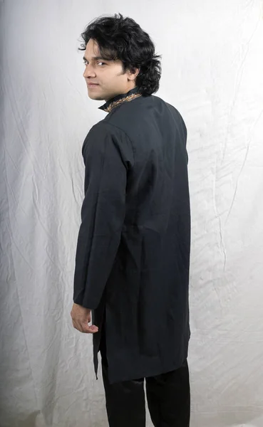 Молодой мужчина-модель в черной курте — стоковое фото