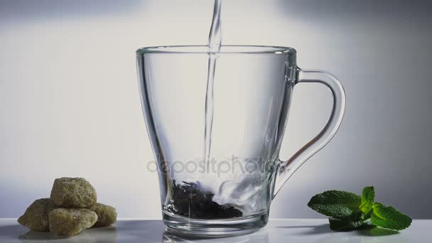 Verser de l'eau bouillante sur les feuilles de thé. Sucre et feuilles de menthe .