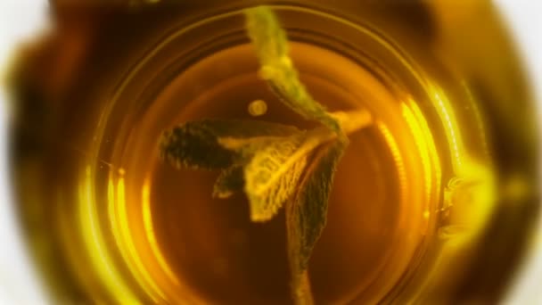Mint leaves in a cup of tea turns around. — Stock Video