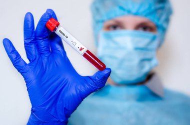 Medical laboratory assistant holding test tube with positive Cor
