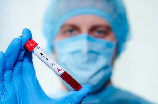 stock image Medical laboratory assistant holding test tube with positive Coronavirus test blood sample.