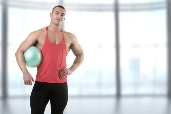 Fit Man em pé segurando uma bola de pilates — Fotografia de Stock