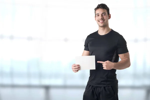Personlig tränare håller ett tomt kort — Stockfoto