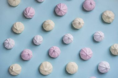 Beze. Mavi zemin üzerine sarı, pembe, beyaz meringues