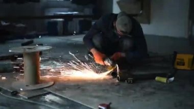 Fabrikada kaynakçı. Metal açı öğütücüsünde kıvılcımlar