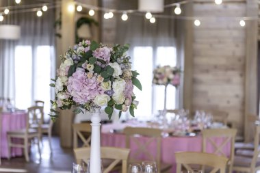 Ziyafette düğün dekoru. Çiçeklerle süslenmiş bir düğün restoranı. Lüks düğün masası dekorasyonu. Özel etkinlik masası kuruldu. Taze çiçek süslemesi.