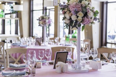 Ziyafette düğün dekoru. Çiçeklerle süslenmiş bir düğün restoranı. Lüks düğün masası dekorasyonu. Özel etkinlik masası kuruldu. Taze çiçek süslemesi.