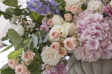 Farklı çiçeklerden oluşan bir düğün buketi; Pinl, leylak, beyaz güller. Düğün teçhizatı. Banliyö restoranında düğün hazırlığı