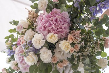 Farklı çiçeklerden oluşan bir düğün buketi; Pinl, leylak, beyaz güller. Düğün teçhizatı. Banliyö restoranında düğün hazırlığı