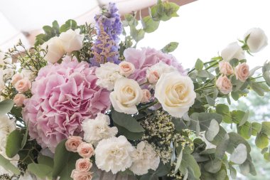 Farklı çiçeklerden oluşan bir düğün buketi; Pinl, leylak, beyaz güller. Düğün teçhizatı. Banliyö restoranında düğün hazırlığı