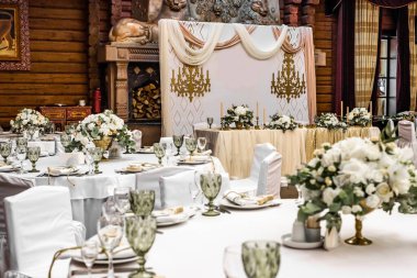 Restoranda beyaz düğün süsü. Lüks düğün düzenlemesi. Düğün ziyafeti dekorasyonu. Restorandaki masalar güzel beyaz şakayıklar ve güllerle süslenmiş.