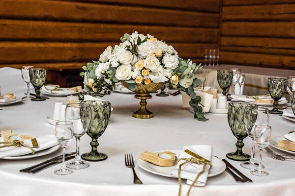 White wedding decoration in restaurant. Luxury wedding arrangement. Wedding banquet decoration. Tables in restaurant decorated with beautiful white peonies and roses