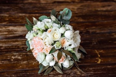 Ahşap arka planda beyaz ve pembe şakayıklardan yapılmış güzel bir düğün buketi. Düğün dekorasyonu. Gelinin düğün buketi. Taze çiçek süslemesi