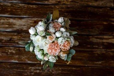 Ahşap arka planda beyaz ve pembe şakayıklardan yapılmış güzel bir düğün buketi. Düğün dekorasyonu. Gelinin düğün buketi. Taze çiçek süslemesi