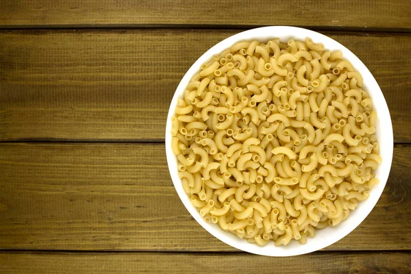 Pastas italianas en plato sobre fondo de madera — Foto de Stock