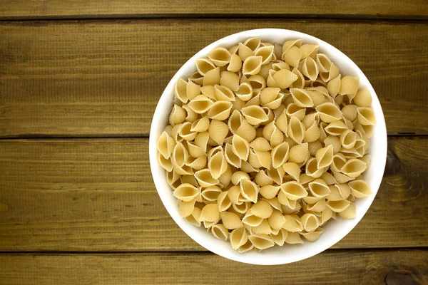 Італійська паста в тарілку з дерев'яними тлі — стокове фото