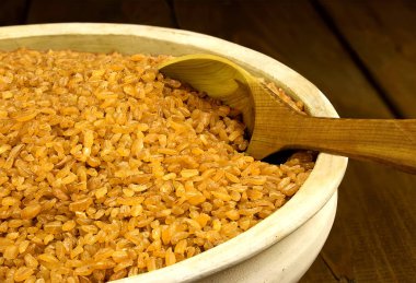 Masanın üzerine kaşıkla bir kil kase kuru bulgur buğday