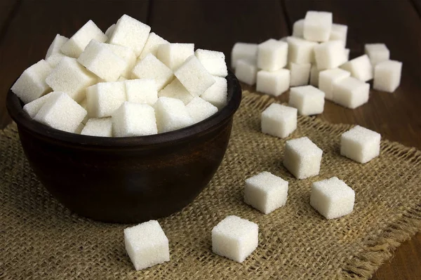 Кубики сахара в кастрюле с деревянной ложкой — стоковое фото