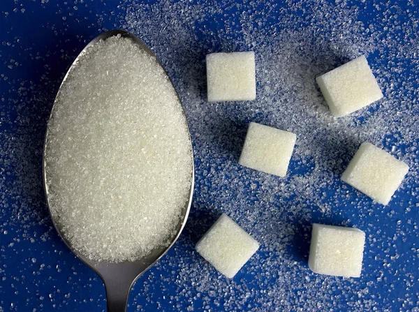 Белый сахар на ложке — стоковое фото