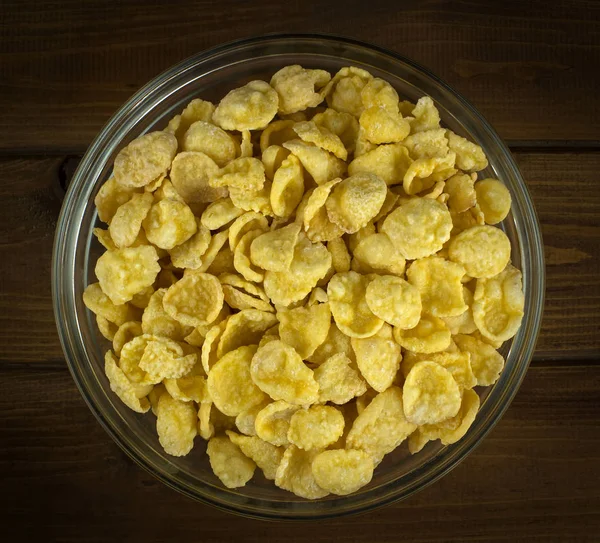 Cuenco con copos de maíz sobre fondo de madera — Foto de Stock