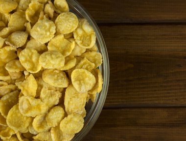 Ahşap arka plan üzerinde Mısır gevreği ile kase