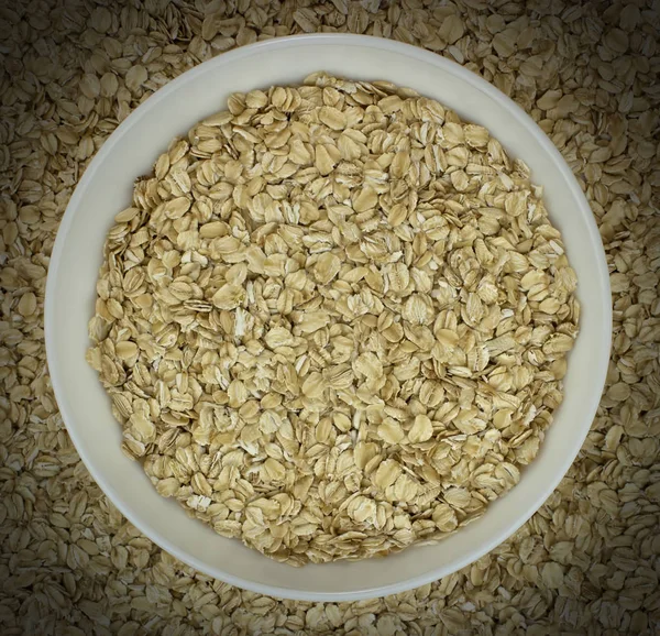 Dry oat flakes oatmeal in bowl on the background — Stock Photo, Image