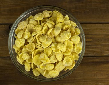 Ahşap arka plan üzerinde Mısır gevreği ile kase