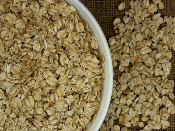 Dry oat flakes oatmeal in bowl on the background — Stock Photo, Image